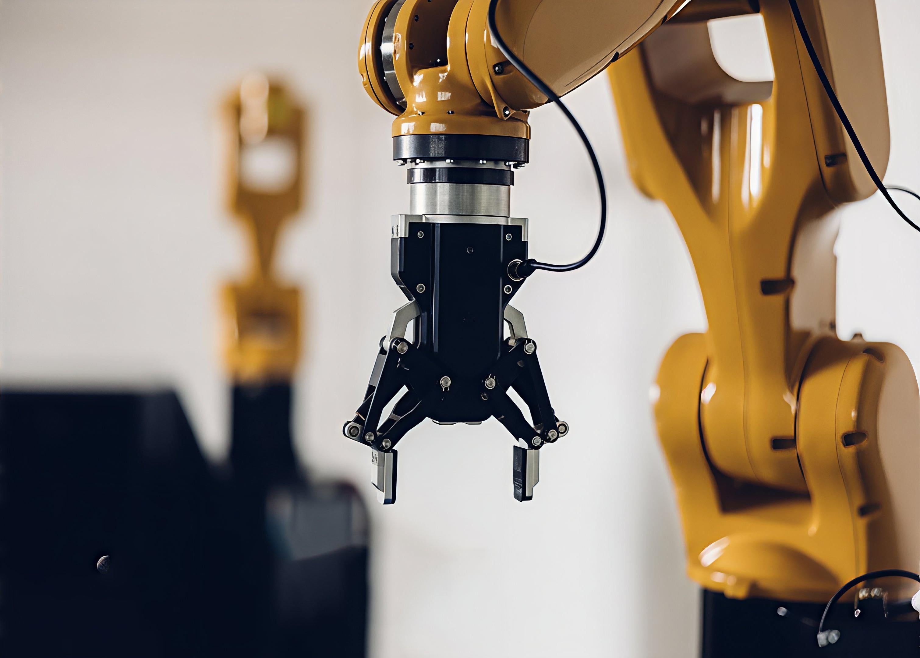 Yellow robot arm with a black end of arm tool